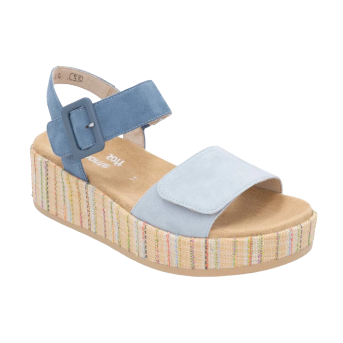 A light blue platform sandal with dark blue backstrap, tan Remonte logo'd footbed and a woven multicolor striped wedge sole.