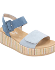 A light blue platform sandal with dark blue backstrap, tan Remonte logo'd footbed and a woven multicolor striped wedge sole.