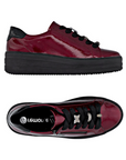 Pair of Burgundy patent leather sneakers with black laces, sparkly lace charms, side zipper and black platform outsole.