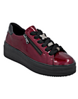 Burgundy patent leather sneaker with black laces, sparkly lace charms, side zipper and black platform outsole.