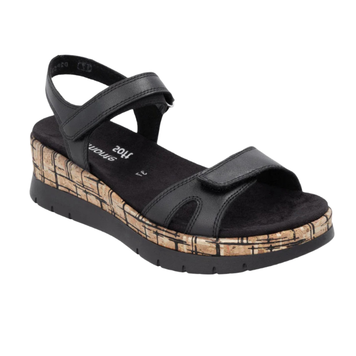 A black wedge sandal with black Velcro straps, black Remonte logo'd footbed, a faux- cork-textured midsole and black platform outsole.