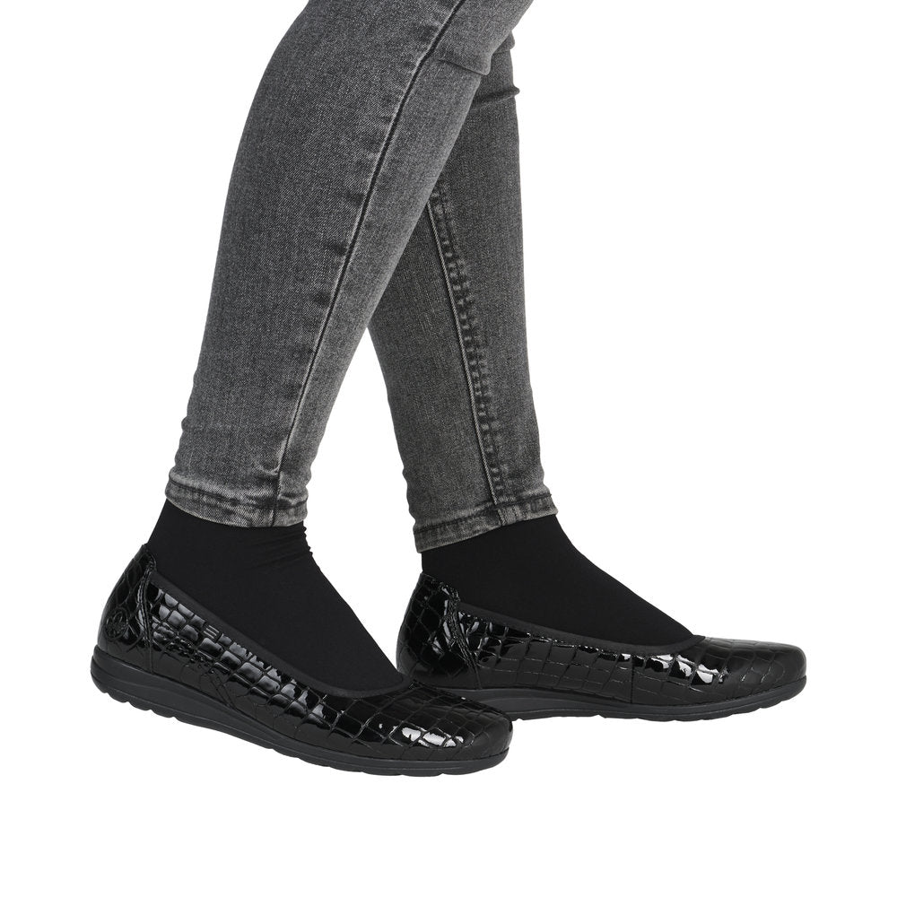 Black slip-on ballet flat worn with gray jeans.