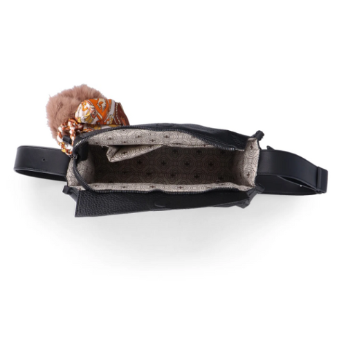 Interior of Black handbag with a fluffy brown pom-pom charm and light grey lining.