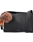 Black handbag with a fluffy brown pom-pom charm.