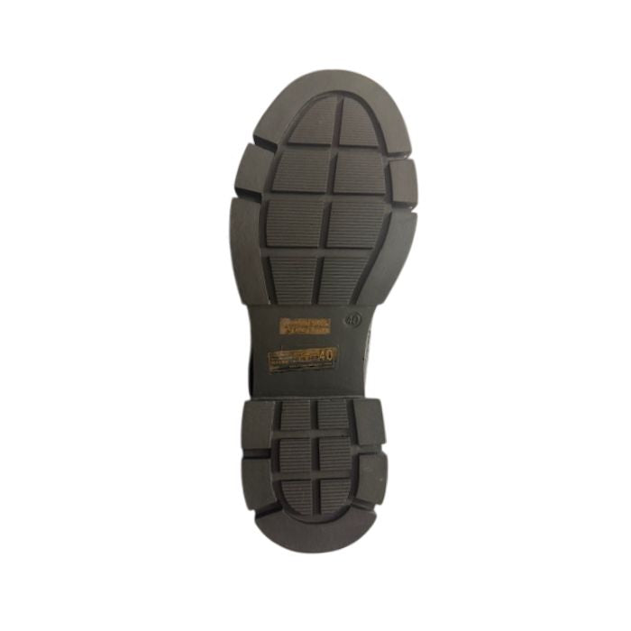 Brown treaded outsole of a Chelsea boot with Romika logo in middle.