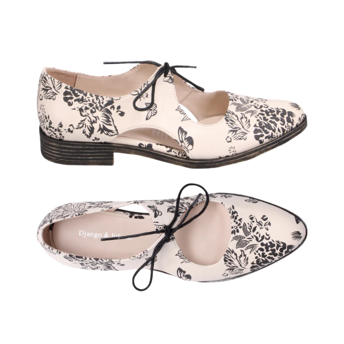 Pair of Beige leather oxfords with black floral print, d’Orsay side cutouts, Django &amp; Juliette logo'd footbed,  and low stacked heel.