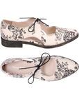 Pair of Beige leather oxfords with black floral print, d’Orsay side cutouts, Django & Juliette logo'd footbed,  and low stacked heel.