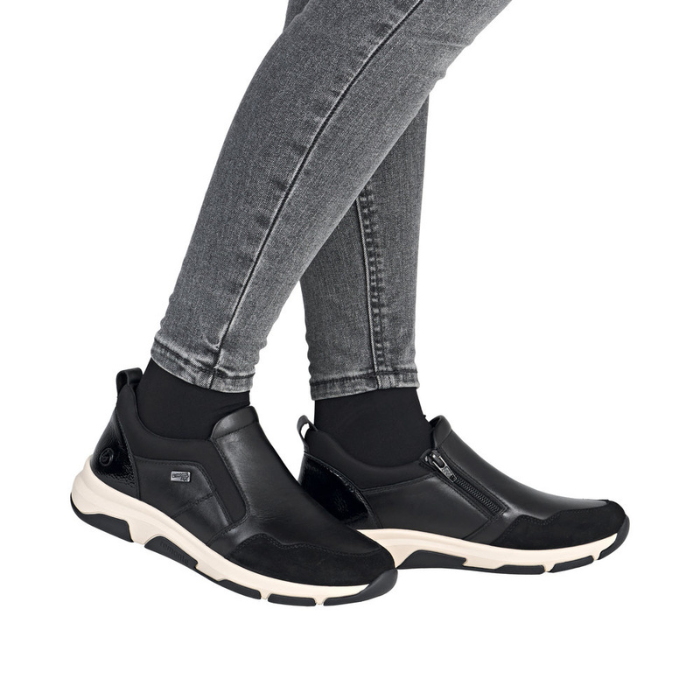 Black slip-on shoes worn with gray jeans.