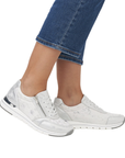 Silver sneakers worn with blue jeans.