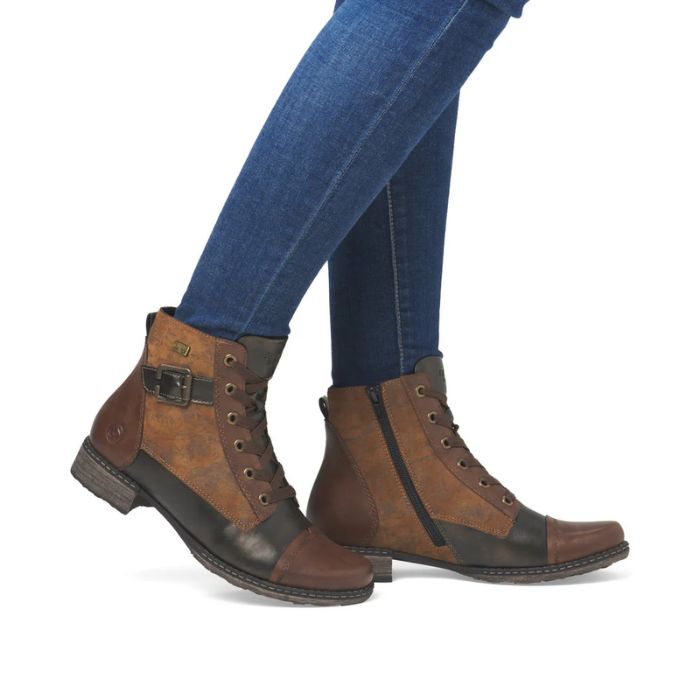 Brown and bronze lace-up boots worn with blue jeans.
