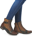Brown and bronze lace-up boots worn with blue jeans.