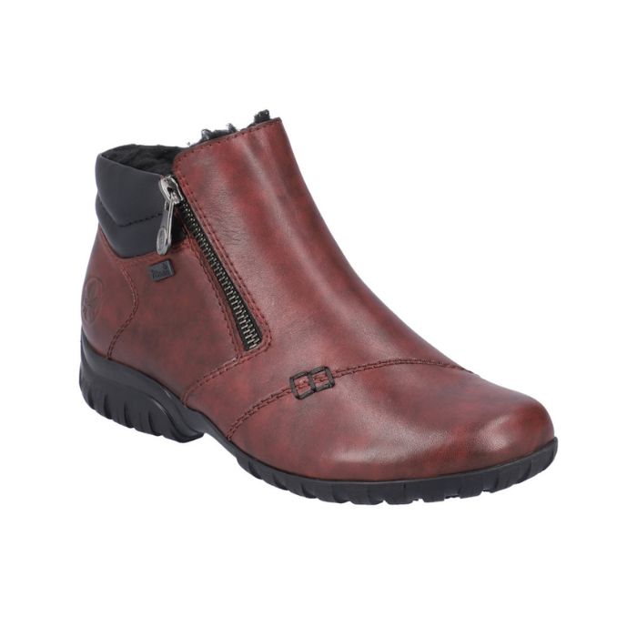 Red ankle boot with black outsole and outside zipper closure.