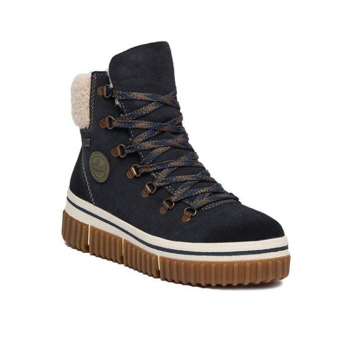 A dark navy blue high-top winter boot with a thick brown lug sole, a cream-colored fleece lining at the collar, and brown laces threaded through metal eyelets.