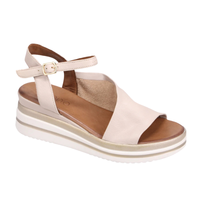 Beige sandal with slingback and open toe d'Orsay style upper with gold buckle, white and gold lined wedge midsole and tan Bueno logo'd footbed.