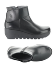 Pair of A black leather ankle boots with a chunky platform outsole, inside zipper and a wide strap across the ankle.