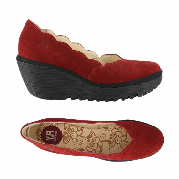 Pair of red suede wedge shoes with a scalloped edge, yellow patterned Fly London logo'd footbed and a chunky black platform outsole.