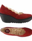 Pair of red suede wedge shoes with a scalloped edge, yellow patterned Fly London logo'd footbed and a chunky black platform outsole.