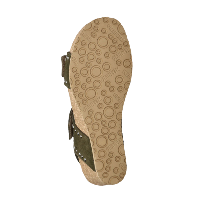 Beige outsole of cork wedge sandal with green straps showing and circle tread pattern with Mephisto stamped in.