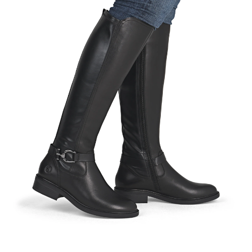Black knee-high boots with a buckle on ankle worn with blue jeans.