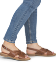 Brown slingback sandals worn with jeans.