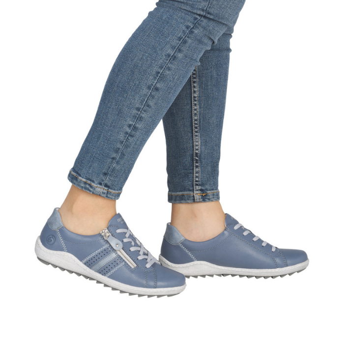 Blue sneakers worn with jeans.