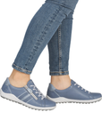 Blue sneakers worn with jeans.