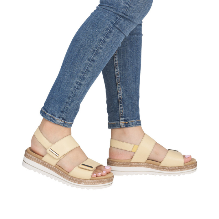 Pale yellow backstrap sandals worn with blue jeans.