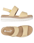 Pair of Backstrap Sandals in yellow with gold accents, two Velcro straps, tan Remonte logo'd footbed, faux jute and white platform midsole and lugged white outsole.