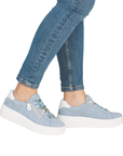 Light blue platform sneakers worn with blue jeans.