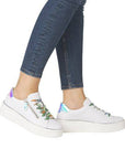 Model wearing white Remonte D1C06 lace-up platform sneakers with colorful laces and iridescent heel detail, styled with jeans.