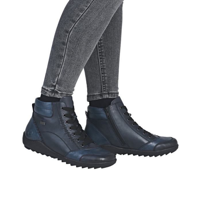 Blue sneaker boots worn with gray jeans.