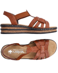 Pair of Brown gladiator inspired backstrap sandals with faux cork platform midsole, tan Rieker logo'd footbed and black outsole.
