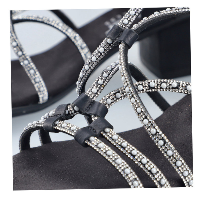 Close up of sandals straps showing diamonds and pearl details.