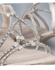 Close up of beige sandals straps showing diamonds and pearl details.