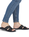 Black sparkly slide sandals worn with blue jeans.