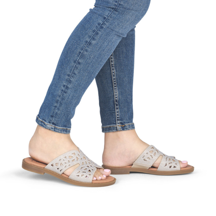 Beige sparkly slide sandal worn with blue jeans.