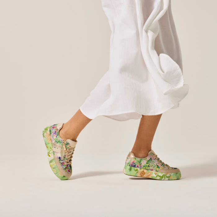 Green Floral sneakers worn with a white outfit.