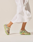 Green Floral sneakers worn with a white outfit.