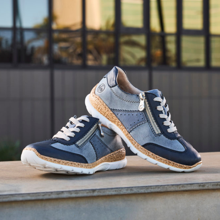 Pair of blue sneakers on a wooden surface with a blurred outdoor background.
