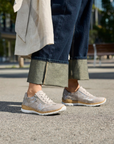 Person wearing shimmery beige sneakers on a city street with blurred background.
