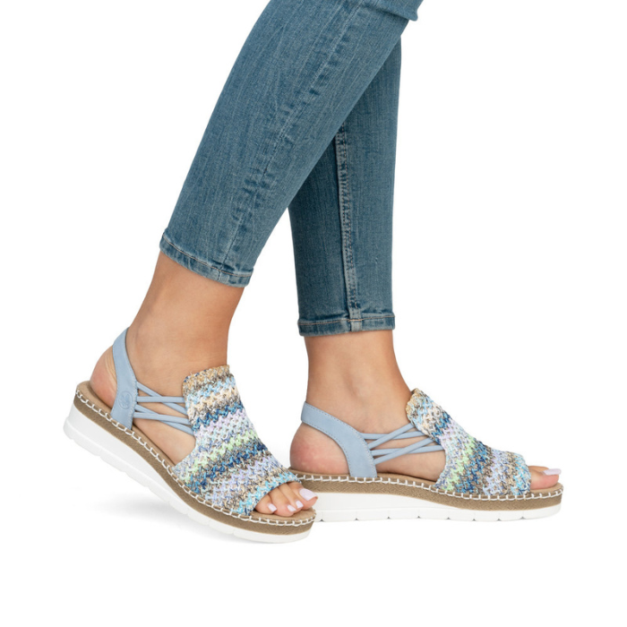 Blue woven wicker sandals worn with light blue jeans.