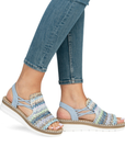 Blue woven wicker sandals worn with light blue jeans.