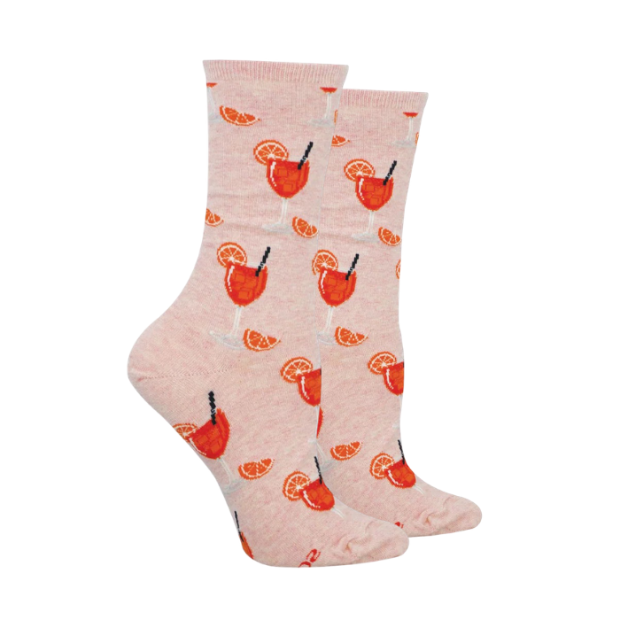 Pair of pink socks with Wine glass pattern full of orange drink, black straw and orange slices.