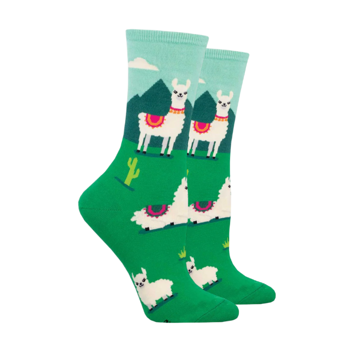 Green socks with a mountain side scene, cacti and Llamas lounging in grass.