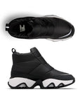 Pair of A black Puffy upper front Zip Ankle Boots with white midsole, Sorel logo on black footbed and a wave pattern rubber outsole.