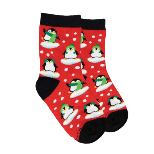 Red socks with penguins in snow wearing green winter hats and scarves.