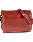 Whiskey brown leather handbag with adjustable strap and Derek Alexander logo embossed on bottom right corner.
