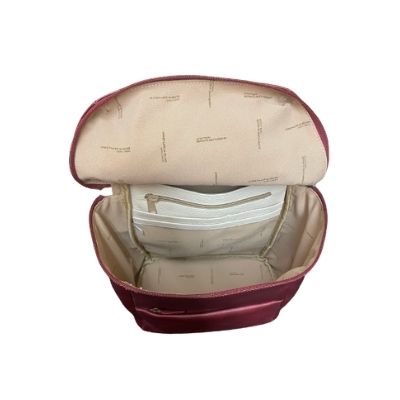 Interior of burgundy backpack, showing beige lining and zippered pockets.