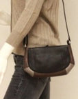 Black and metallic leather bag displayed on a mannequin. 