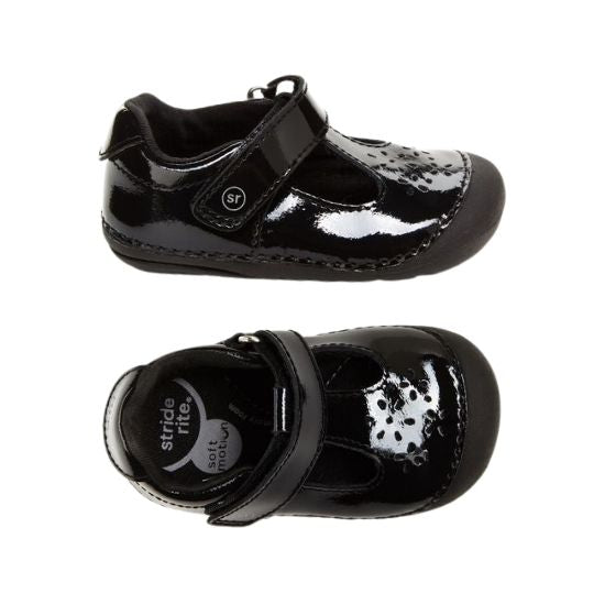 Pair of black patent leather Mary-Jane with floral cutout detail.